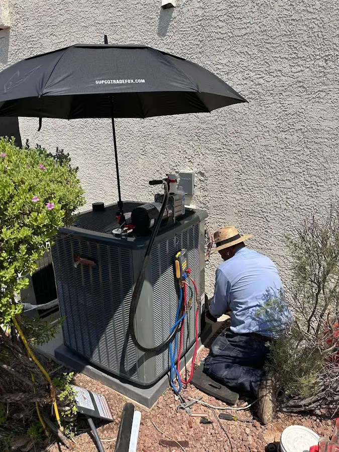 HVAC technician performing outdoor AC maintenance in Dumbarton